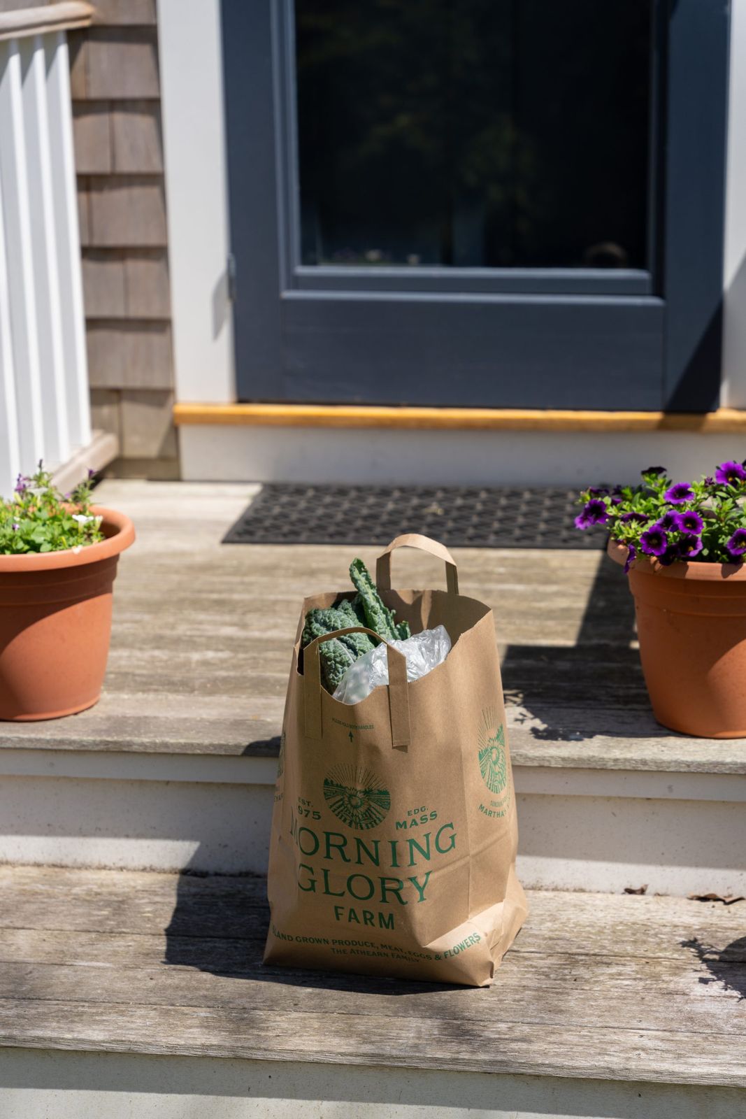 A grocery bag from Morning Glory Farm on the front steps